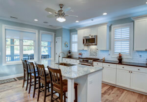 Luxury island kitchen with blue walls, white-trim windows and bluish gray ceiling