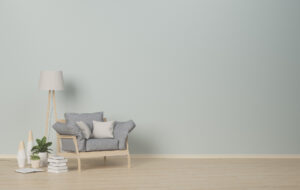 Custom Interior Painting Florida An nearly-empty room with a small chair, lamp, and plant.