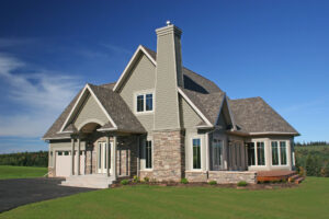 Luxury two-story home or rural wooded lot with chimney at the facade and sporting earthy tan colors and stone facade