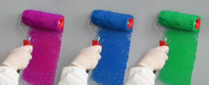 Photo illustration of a painter's right hand triplicated side by side and rolling on repsectively magenta, blue, and green paints 