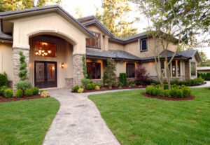 Picture of the exterior of a recently painted two-story house with a large front yard.
