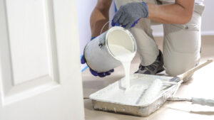 Interior House Painters Florida Close up of painter hands with gloves painting the wall edge with brush